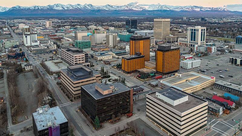 Downtown Anchorage, Alaska, with snow-covered mountains in the distance.
