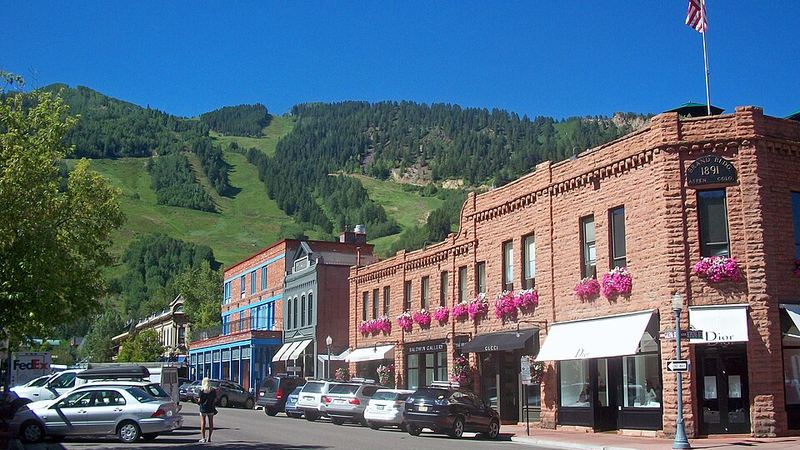 Historic downtown Aspen storefronts with ski slopes behind them, Colorado.