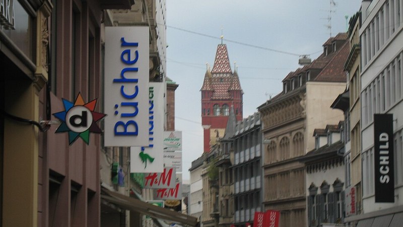 Historic shopping street and clock tower in Basel, Switzerland.