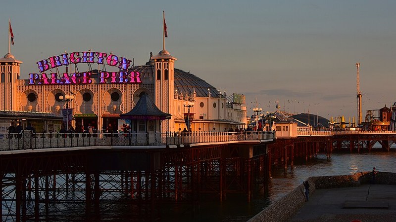 Brighton Palace Pier illuminated by warm evening light in England.