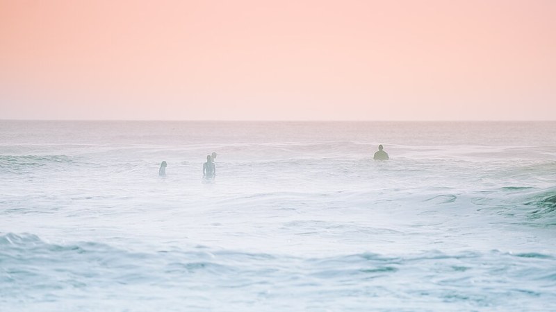 Surfers in the pastel morning surf at Cocoa Beach, Florida.