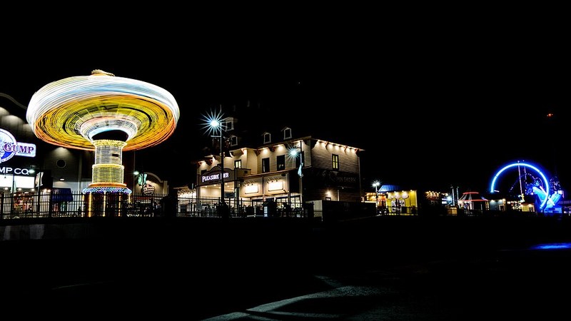 Illuminated amusement rides on Galveston's Pleasure Pier, Texas, at night.