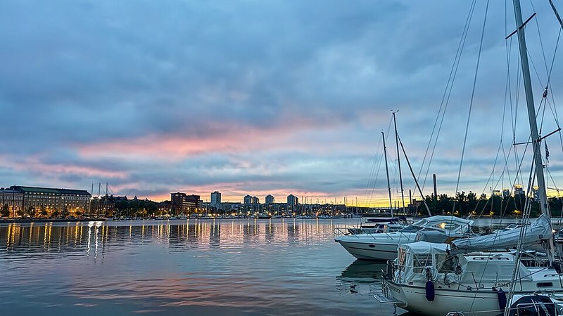 Boats and waterfront buildings at sunset in Helsinki, Finland.