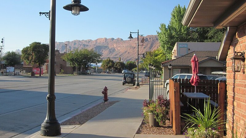 Main Street in Moab, Utah, with red rock cliffs in the distance.