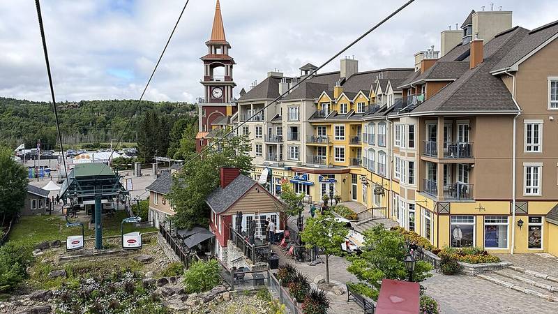 Colourful buildings and the Tour des Voyageurs clock tower in Mont-Tremblant resort village, viewed from the gondola.