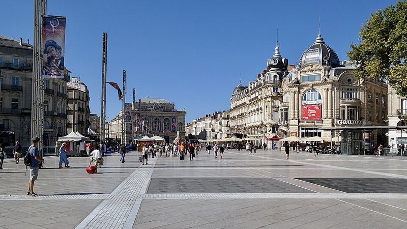 Pedestrian square and historic buildings at Place de la Comédie in Montpellier, France.