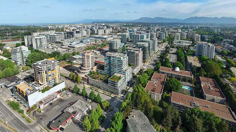 Aerial view of downtown Richmond, British Columbia, with mountains on the horizon.