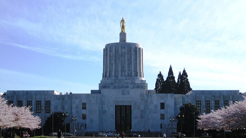 Oregon State Capitol in Salem with flowering trees.