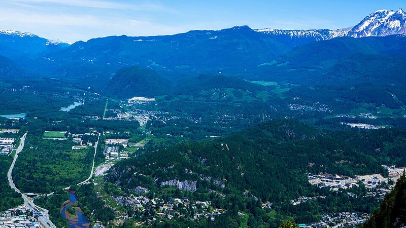 Squamish's forested valley and neighbourhoods beneath mountains, viewed from the Stawamus Chief.