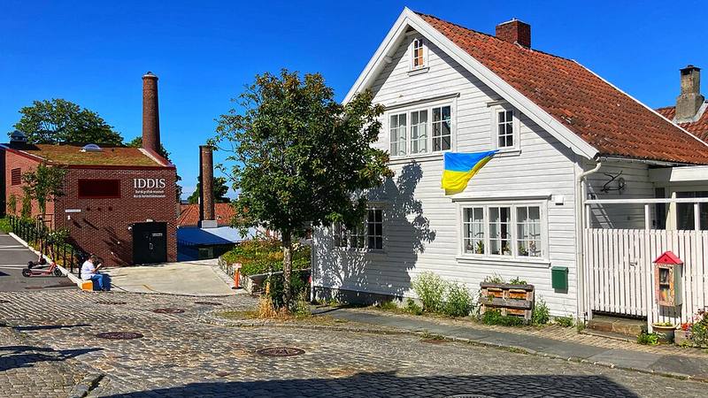 Historic white wooden houses along a cobblestone street in Old Stavanger, Norway.