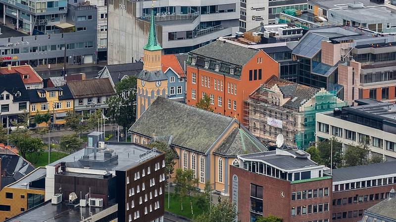 Tromsø Cathedral surrounded by colorful city buildings in Norway.