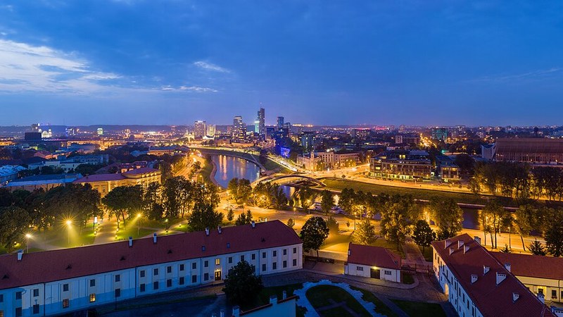 Vilnius, Lithuania, river and modern skyline illuminated at dusk.