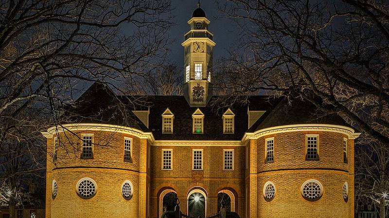 Colonial Williamsburg's Capitol building illuminated at night in Virginia.