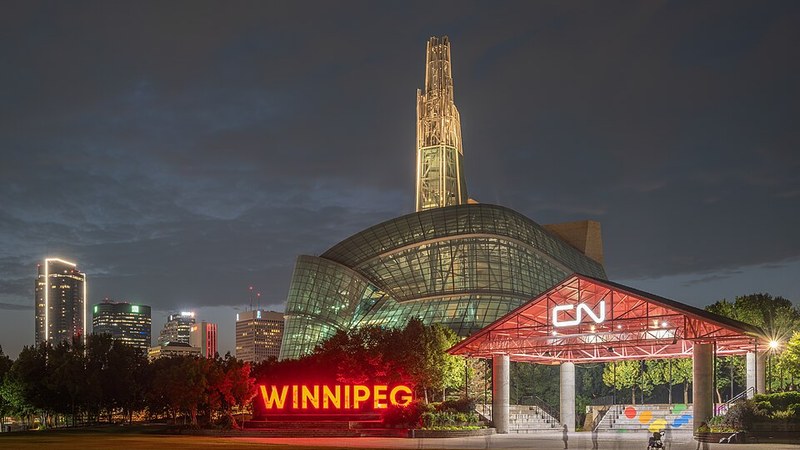The illuminated Canadian Museum for Human Rights and Winnipeg sign at The Forks after dark.